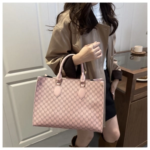 Vue détaillée du sac cabas rose avec imprimé monogramme M et poignées robustes