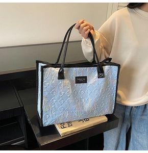 Détail d'un sac fourre-tout matelassé bleu clair avec broderies et écusson New York