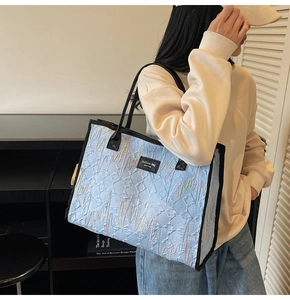Détail du sac cabas matelassé bleu clair avec broderie vagues colorées et poignée