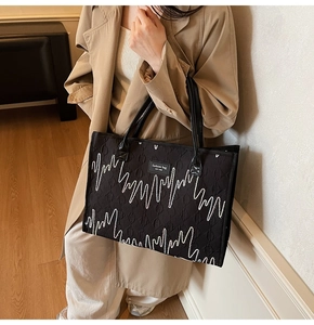 Détail du sac cabas noir avec broderie vagues blanches et logo New York fashion