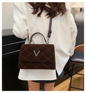 Détail du sac matelassé marron foncé avec logo V argenté et bandoulière en cuir