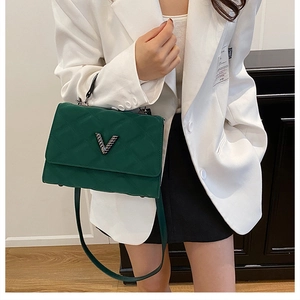 Détail d'un sac à main matelassé vert foncé avec logo V argenté et bandoulière