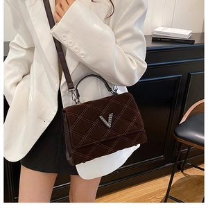 Vue détaillée du sac bandoulière en daim matelassé marron foncé avec boucle en métal