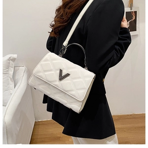 Gros plan du sac à main matelassé blanc avec logo V en métal et bandoulière amovible
