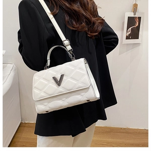 Détail d'un sac à main blanc matelassé avec logo en V et bandoulière en cuir souple