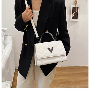 Détail du sac à main matelassé blanc en similicuir avec logo V noir et bandoulière fine