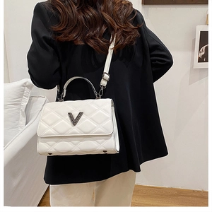 Vue détaillée d'un sac matelassé blanc doté d'un fermoir à boucle métallique en forme de V