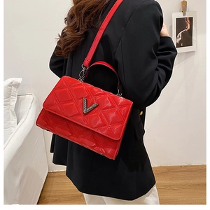 Vue détaillée du sac à bandoulière matelassé rouge avec finition brillante et logo V