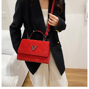 Détail du sac à main rouge en cuir verni matelassé avec logo V brillant et poignée