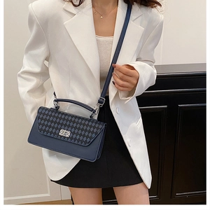 Detail der blauen Handtasche mit Rautenmuster, Silberschnalle und elegantem Griff