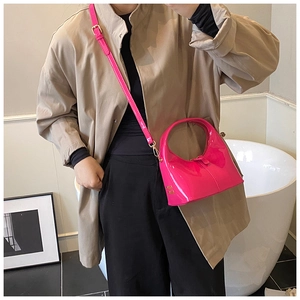 Dettaglio borsa rosa shocking in pelle lucida con logo in metallo dorato sulla base