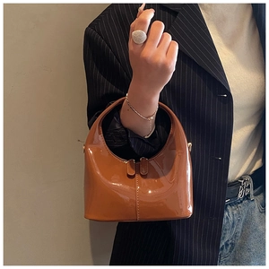 Dettaglio borsa in pelle verniciata lucida marrone scuro con elegante manico