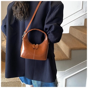 Dettaglio borsa hobo in pelle verniciata marrone lucida con zip e tracolla regolabile