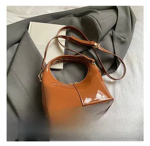 Dettaglio borsa marrone lucida in pelle verniciata con cerniera dorata