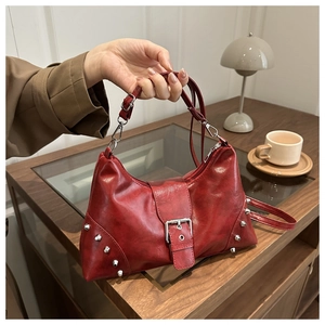 Detailaufnahme der roten Retro-Tasche mit Nieten und glänzender Lederstruktur