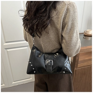 Detail of vintage black tote bag with silver studs worn as a stylish underarm bag