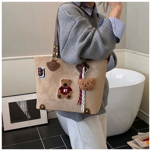 Khaki Shopper Tasche mit Teddybär-Stickerei und Plüsch-Anhänger an der Schulter getragen