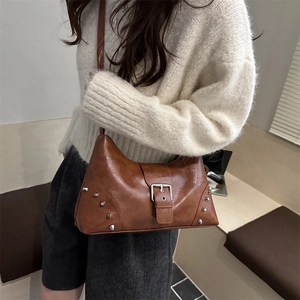 Braune Retro-Tragetasche mit Nieten und Metallschnallen in Lifestyle-Umgebung gezeigt