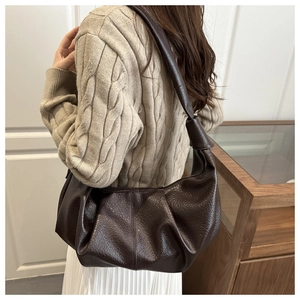 Detail showing deep brown textured leather and soft pleated design of this crossbody bag