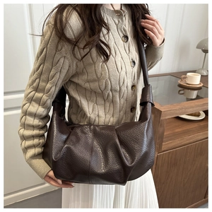 Detail of dark brown lychee textured leather croissant bag with stylish pleats