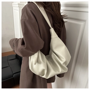 Detail of soft cream leather tote with lychee texture and pleated slouchy hobo style