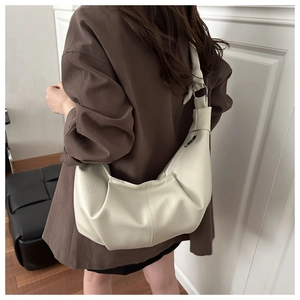 Detail of soft creamy white hobo bag with pleated texture and wide shoulder strap