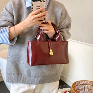 Vintage red patent leather bucket handbag with gold orb pendant for women