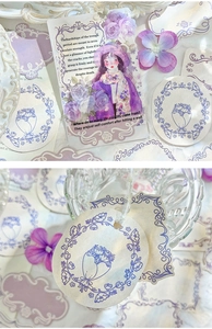 Detailed close-up of vintage purple floral paper stickers and Victorian style girl cards