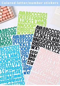 Gros plan d'autocollants colorés de lettres et chiffres près d'un clavier rose