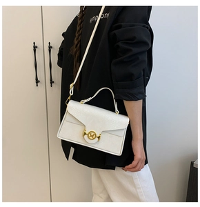 Détail du sac à main blanc à texture serpent avec boucle dorée logo M et bandoulière