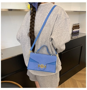 Sac bandoulière bleu à motif serpent avec logo M doré et bandoulière ajustable