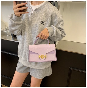 Détail du sac boîte lilas à motif serpent avec une boucle métallique dorée logo M