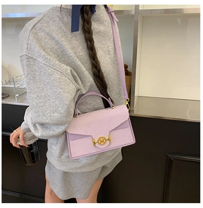 Détail du sac bandoulière violet effet serpent avec boucle dorée M et texture riche