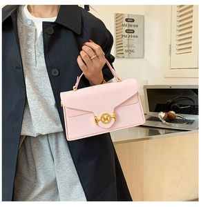 Gros plan du sac boîte rose à motif serpent avec fermoir doré à anneau logo M
