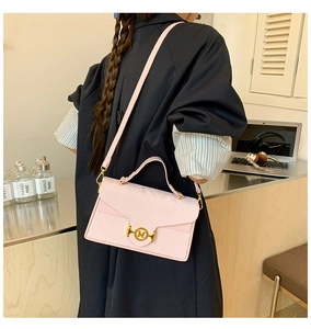 Détail du sac à main rose en similicuir crocodile avec boucle en métal doré et logo M
