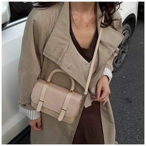 Détail du petit sac à main carré avec rabat en texture tressée et double boucle décor