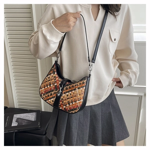 Detail of multi-color woven pattern on hobo shoulder bag with black leather strap