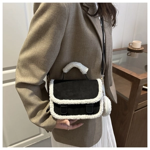 Detail of vintage crossbody bag showing contrast white fleece trim and black suede texture