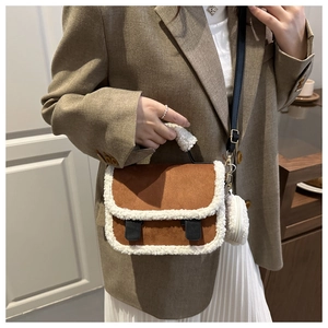 Dettaglio borsa a tracolla in camoscio marrone con bordo in shearling e charm di peluche