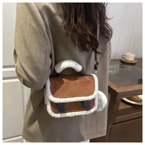 Detail of winter crossbody bag with brown suede and white faux shearling trim accents