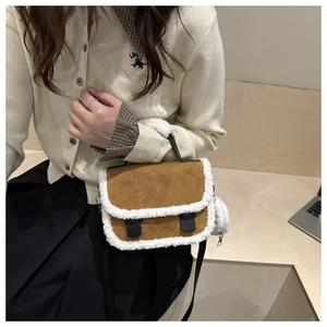 Detail of brown suede crossbody bag with white fleece trim and round plush coin purse
