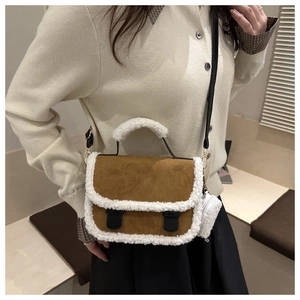Brown suede saddle bag worn by model featuring white faux shearling trim and strap details