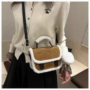 Detail of brown faux suede saddle bag featuring white shearling trim and black strap