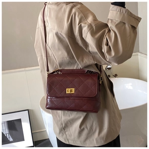 Vista lateral del bolso bandolera acolchado rojo oscuro con cierre dorado en gabardina