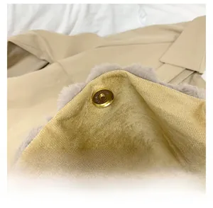 Gros plan du fermoir magnétique doré sur sac en peluche avec doublure en velours rayé