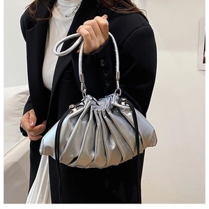 Close-up of metallic silver pleated cloud bag with circular handle and black drawstring