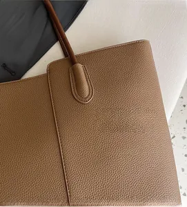 Detail of caramel brown lychee grain leather tote bag with premium stitching accents