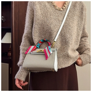 Detailed view of silver matte suede bag with decorative silk scarf on the top handle