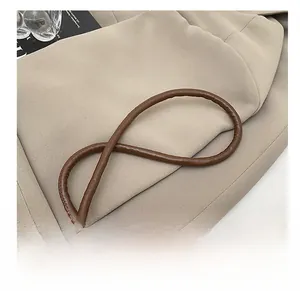 Close-up of brown pleated leather shoulder strap with polished silver metal buckle