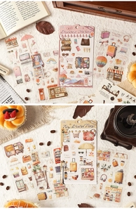 Detailed view of vintage travel stickers featuring luggage and coffee on white linen
